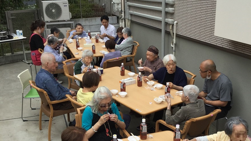 ご利用者さま全員で芋煮を召し上がっている